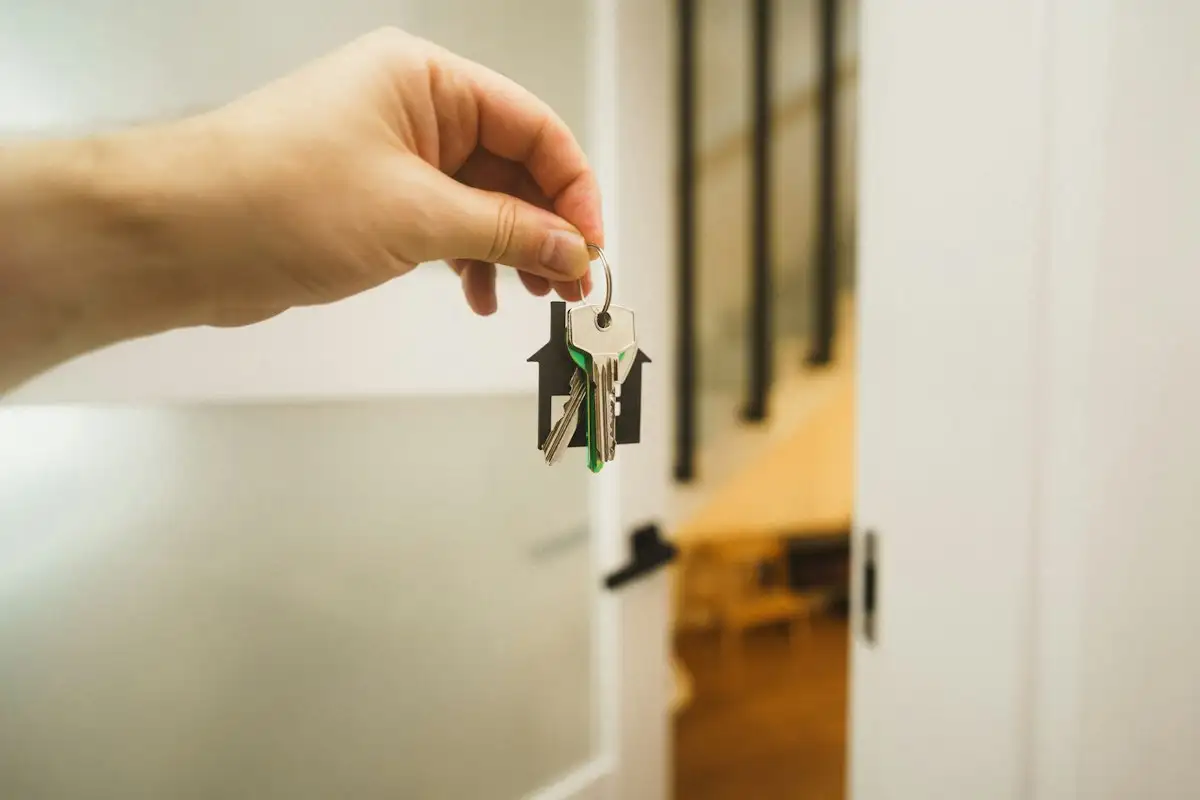 Hand holding a key at a door