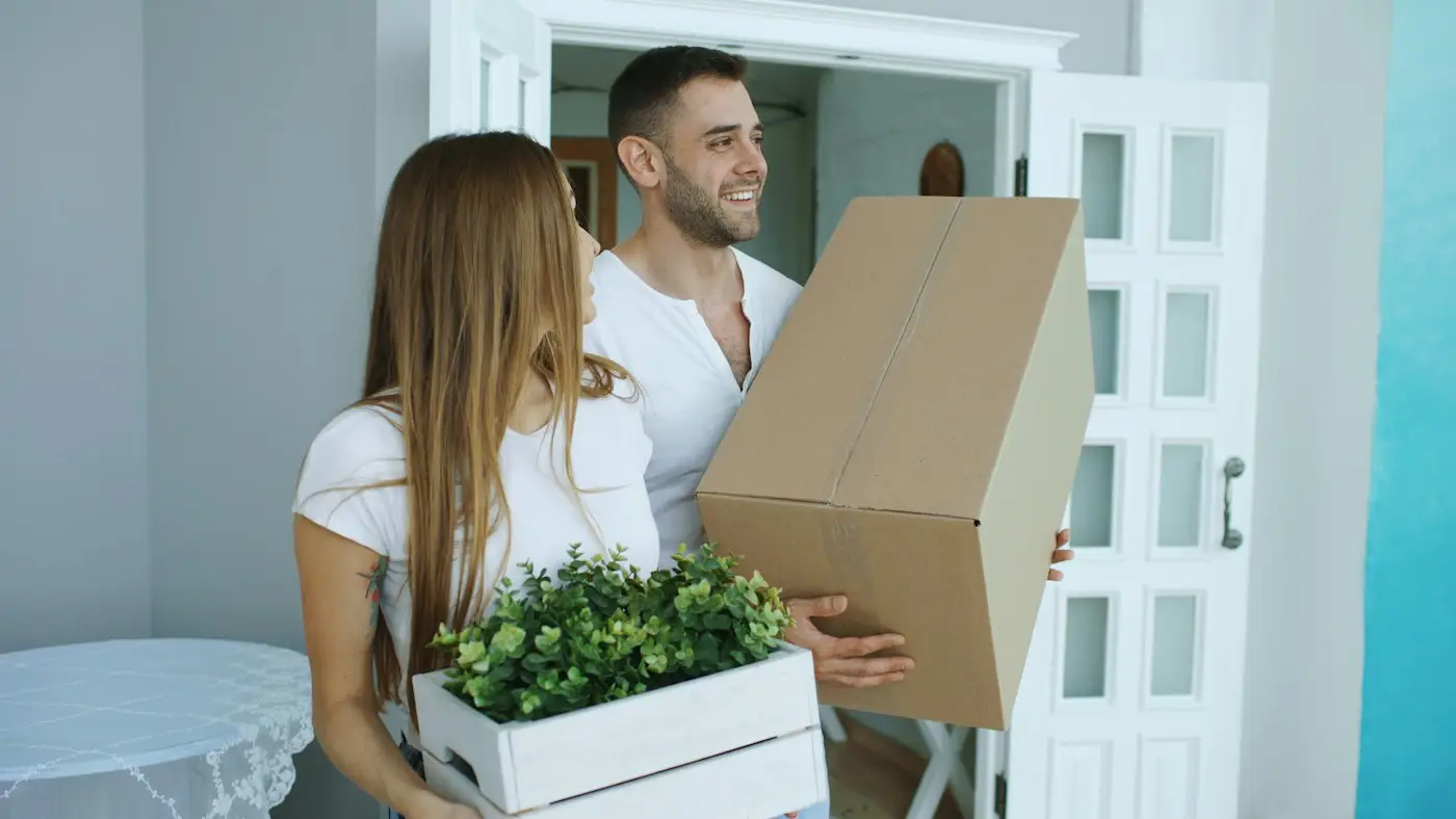 Couple carrying moving boxes